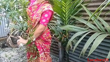 A horny Bengali housewife gets naughty with her husband outdoors in a red saree